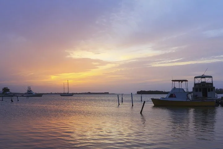 Bateaux amarrés dans une baie tranquille lors d’un coucher de soleil pittoresque et coloré.